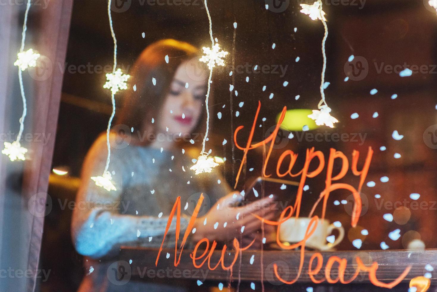 hermosa mujer joven sentada en la cafetería, bebiendo café. navidad, feliz año nuevo, día de san valentín, concepto de vacaciones de invierno foto