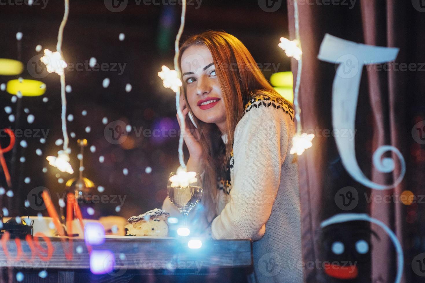 Young beautiful woman sitting in cafe, drinking wine. Christmas, new year, Valentines day, winter holidays concept photo