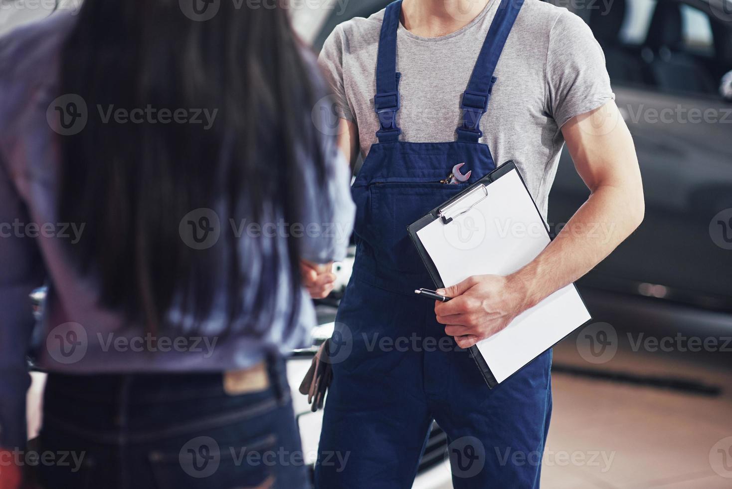 husband car mechanic and woman customer make an agreement on the repair of the car photo