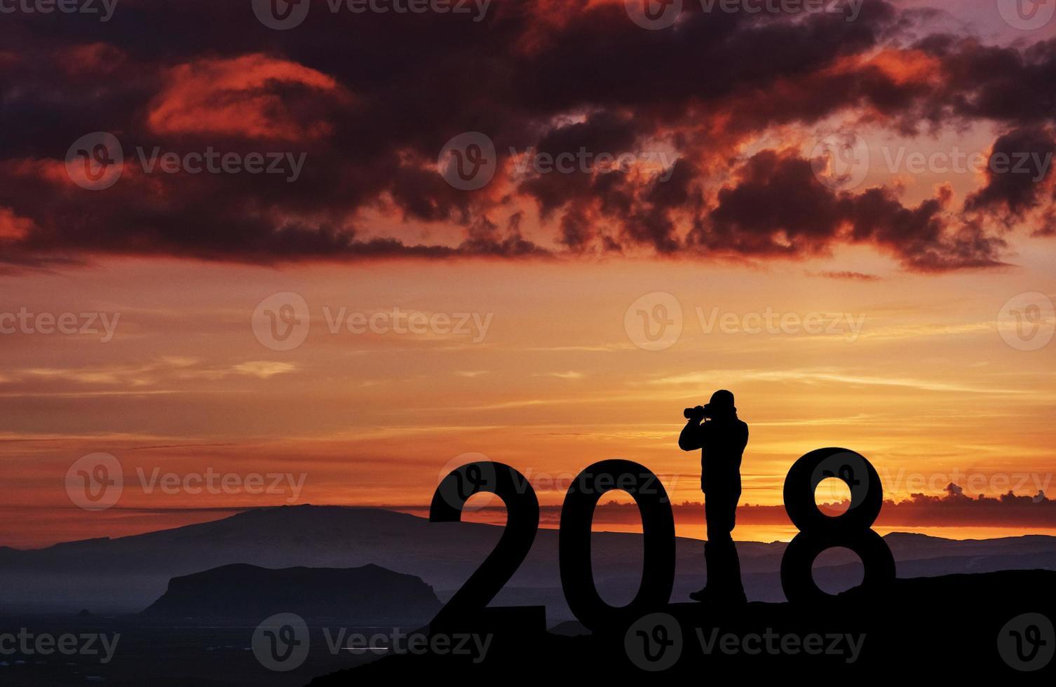 joven fotógrafo de silueta para el año nuevo 2018 fondo de la puesta de sol foto