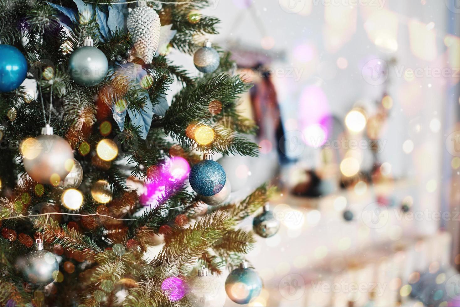 cerca de coloridos adornos en el árbol de navidad. feliz año nuevo y navidad. efecto suave de luz bokeh foto