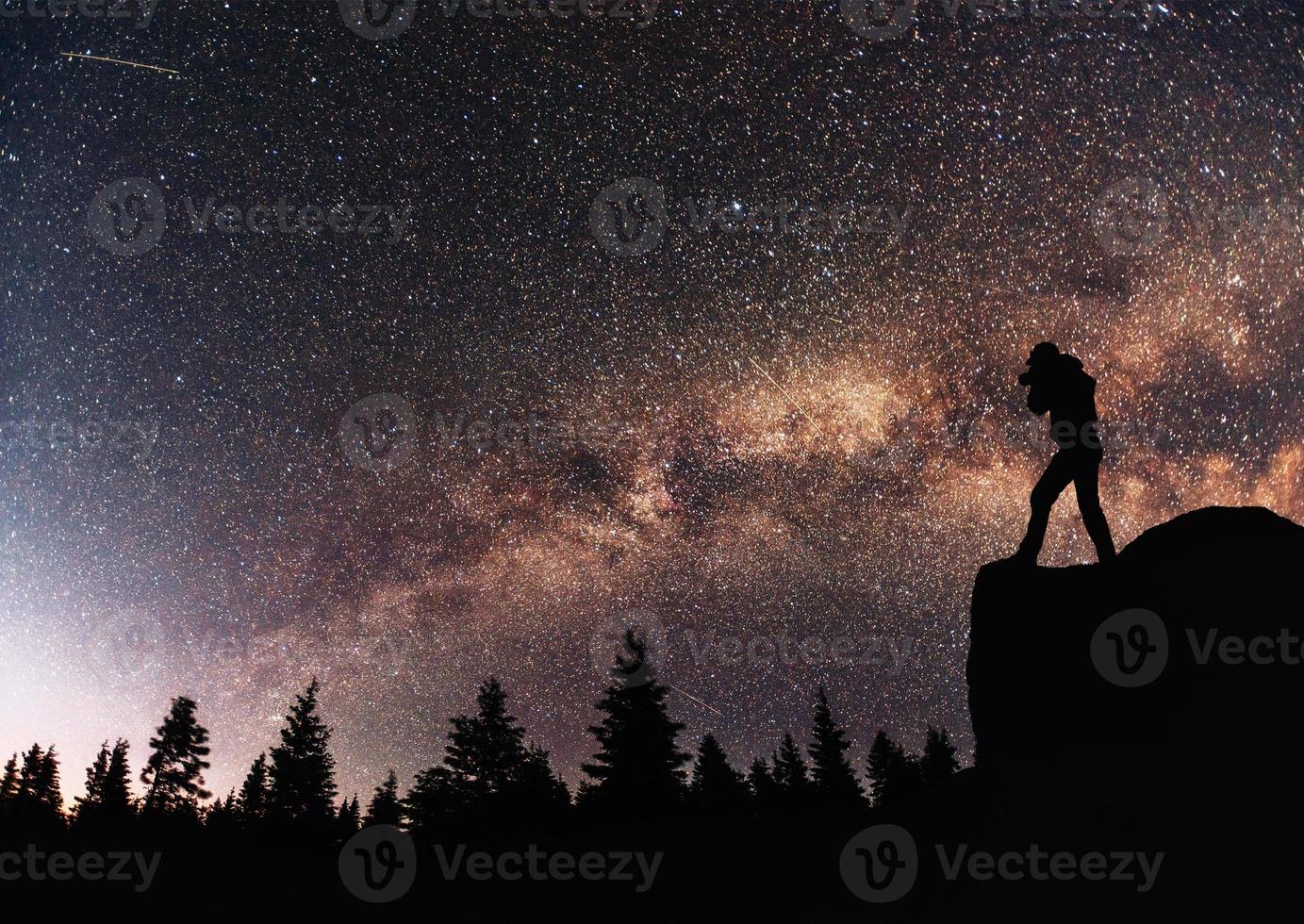 fotógrafo de naturaleza de silueta con cámara digital, fondo de la galaxia de la vía láctea en un tono de cielo oscuro de estrella brillante foto
