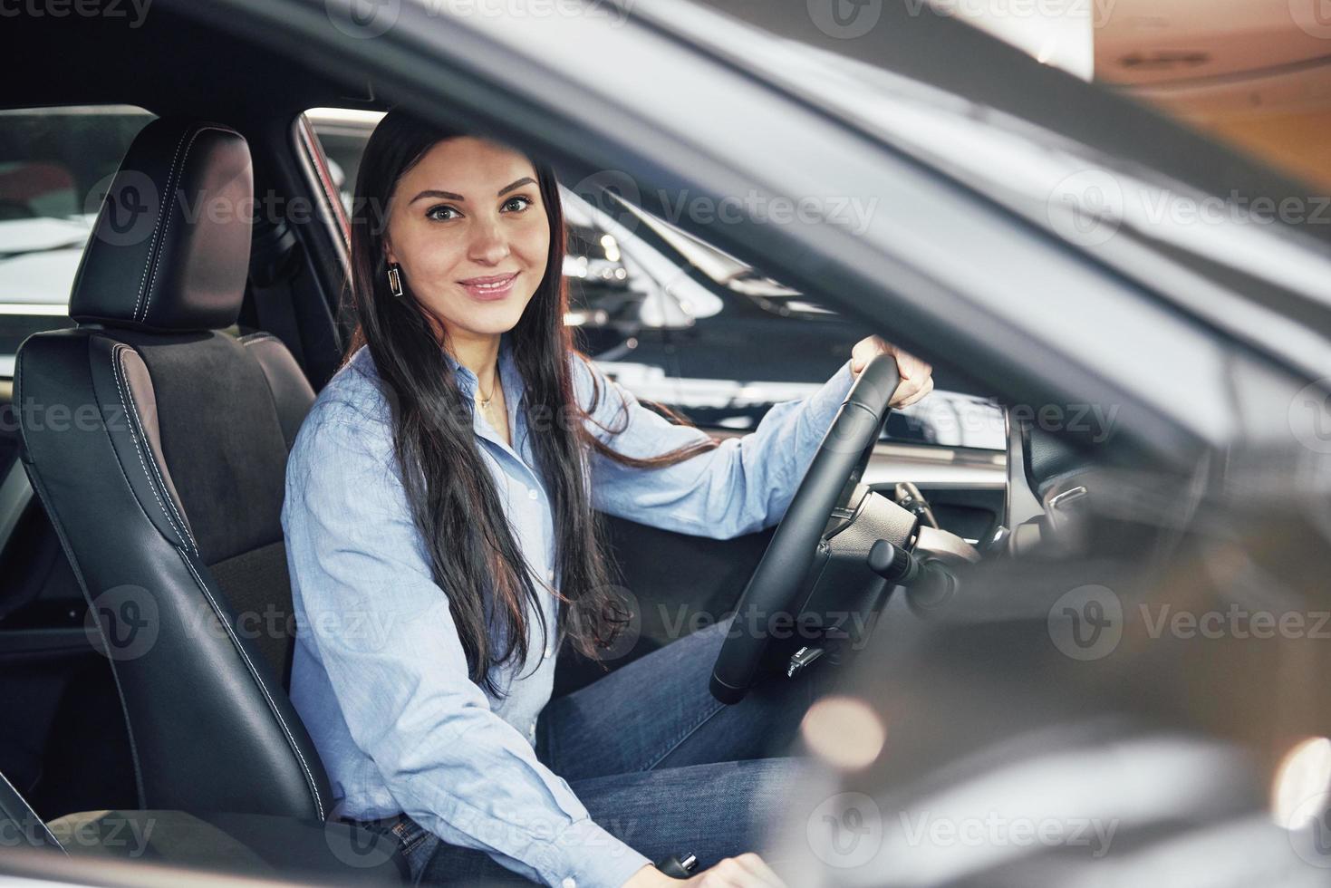 auto business, car sale, consumerism and people concept - happy woman taking car key from dealer in auto show or salon photo