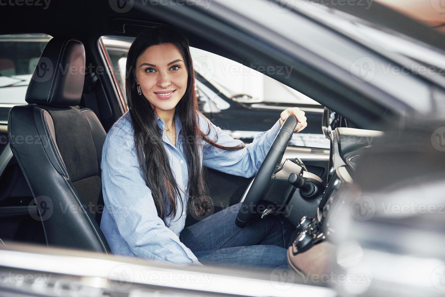 auto business, car sale, consumerism and people concept - happy woman taking car key from dealer in auto show or salon photo