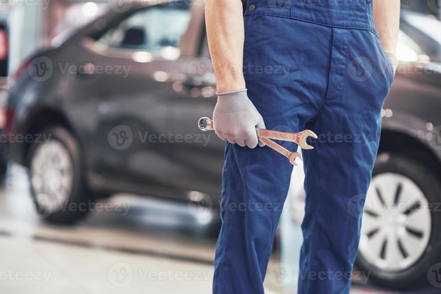 Hand of car mechanic with wrench. Auto repair garage photo