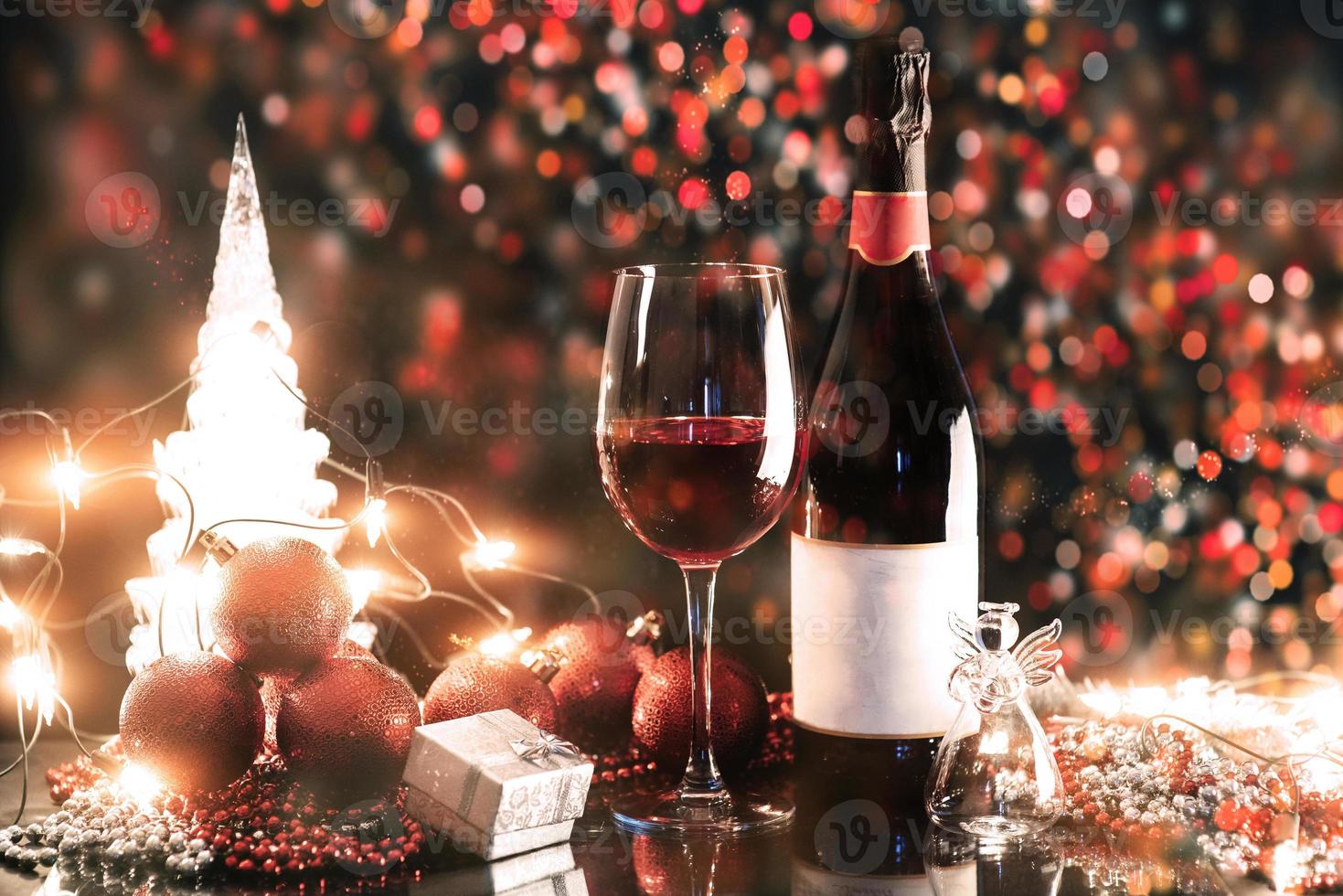 Christmas and New Year. Festive decorations, bottle of red wine and glass on the dark background. Happy New Year and Christmas. Bokeh light soft effect photo