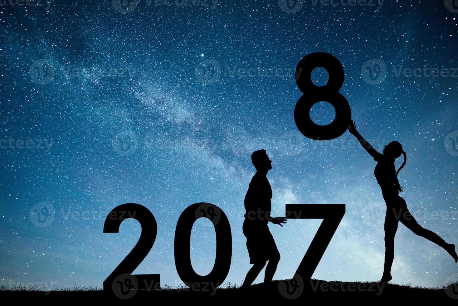 Silhouette young girl and guy. Happy 2018 new year. Background of the Milky Way galaxy on a bright star dark sky tone. Concept change year 2017 to 2018 photo