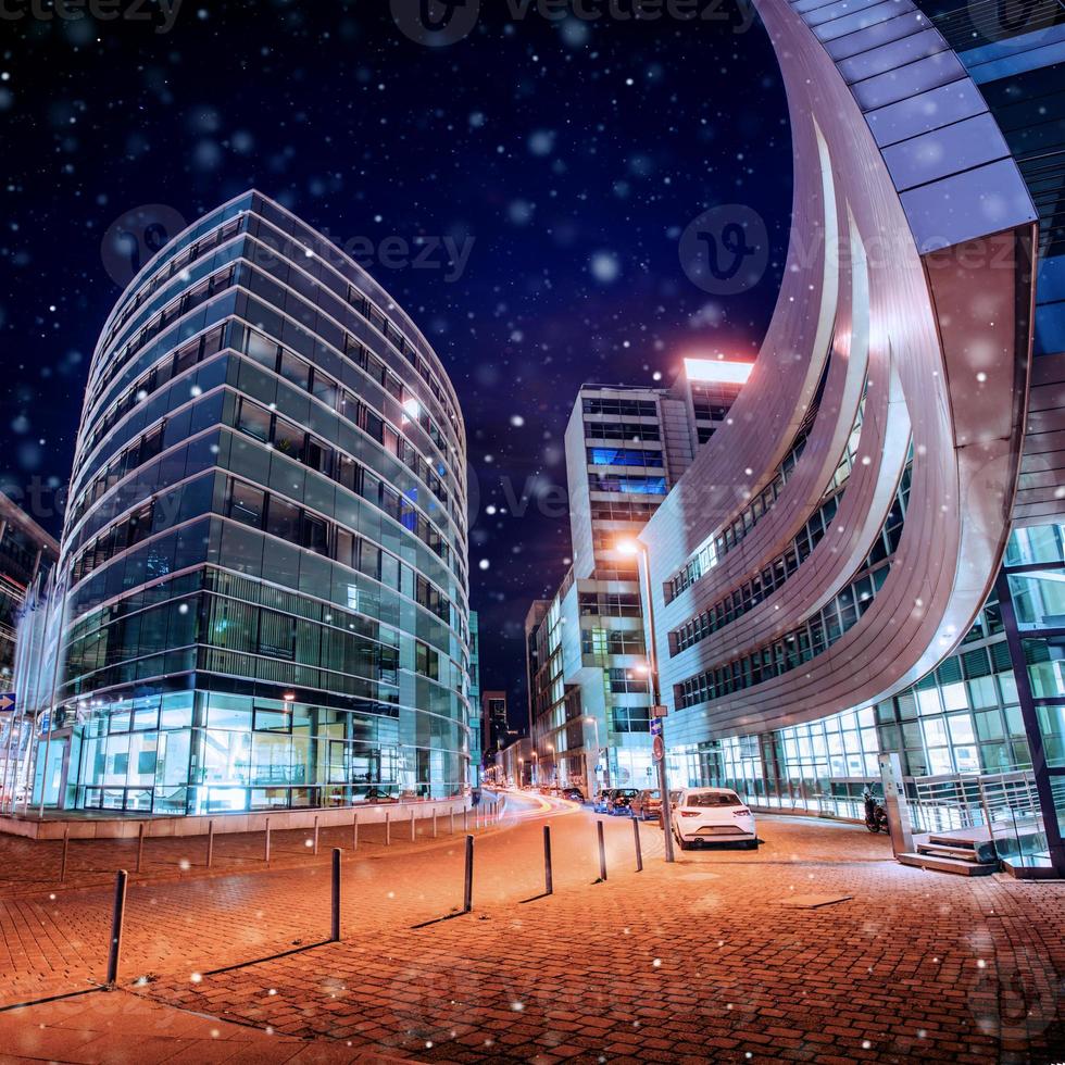 Panorama of the night city of Dusseldorf in winter during a snowstorm. Bokeh light effect, soft filter photo