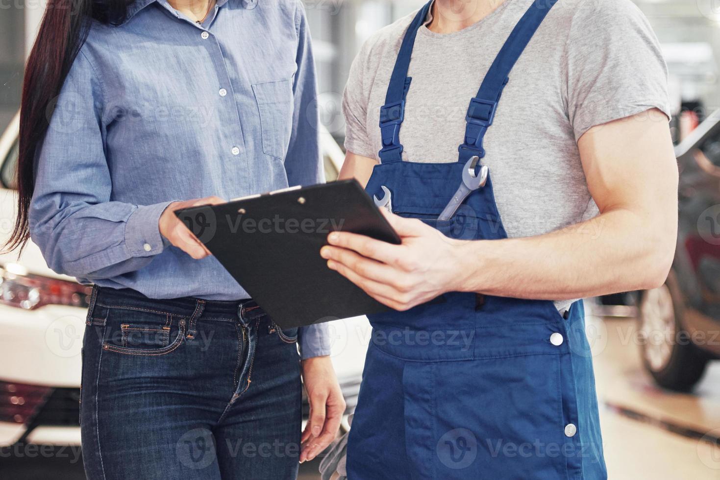A man mechanic and woman customer discussing repairs done to her vehicle photo