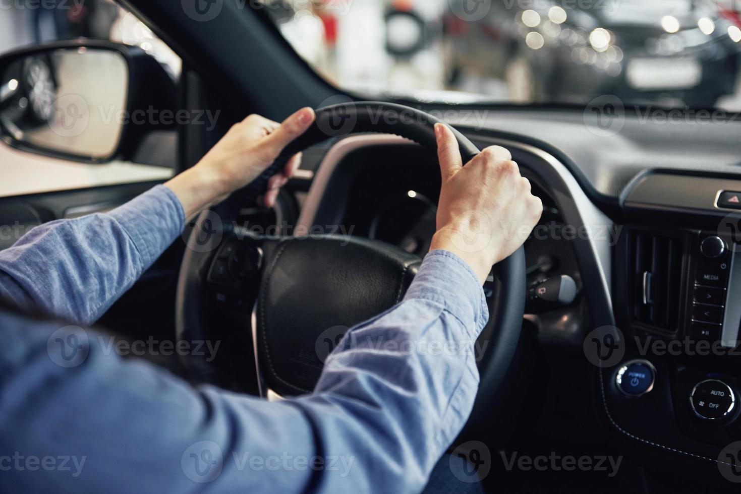 auto business, car sale, consumerism and people concept - happy woman taking car key from dealer in auto show or salon photo