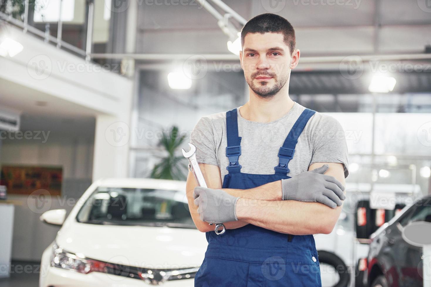 Hand of car mechanic with wrench. Auto repair garage photo