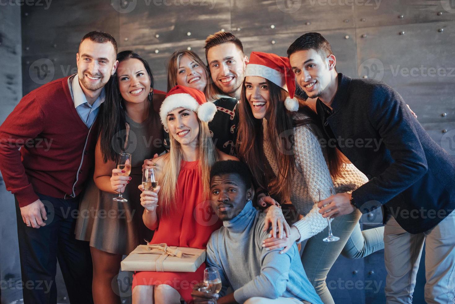 New Year is coming. Group of cheerful young multiethnic people in Santa hats on the party, posing emotional lifestyle people concept photo