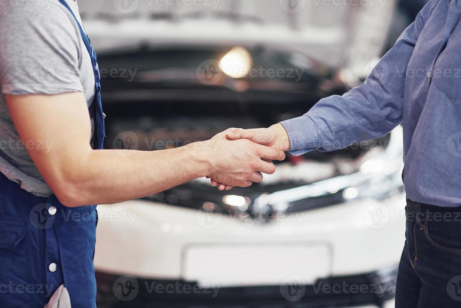 husband car mechanic and woman customer make an agreement on the repair of the car photo