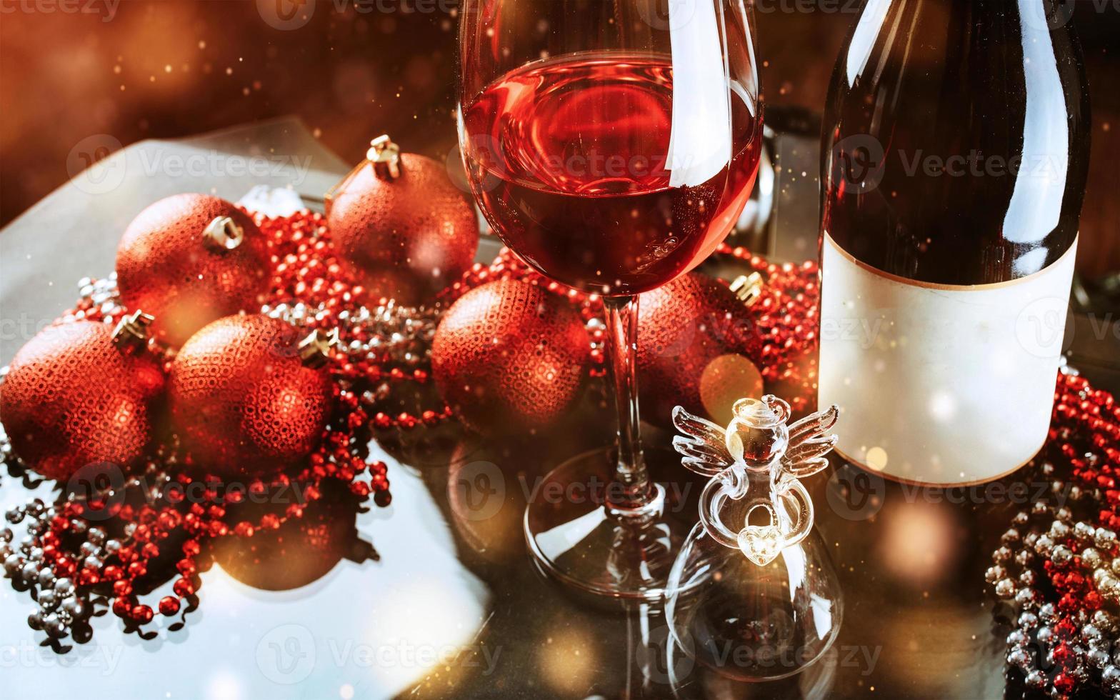 Christmas and New Year. Festive decorations, bottle of red wine and glass on the dark background. Happy New Year and Christmas. Bokeh light soft effect photo