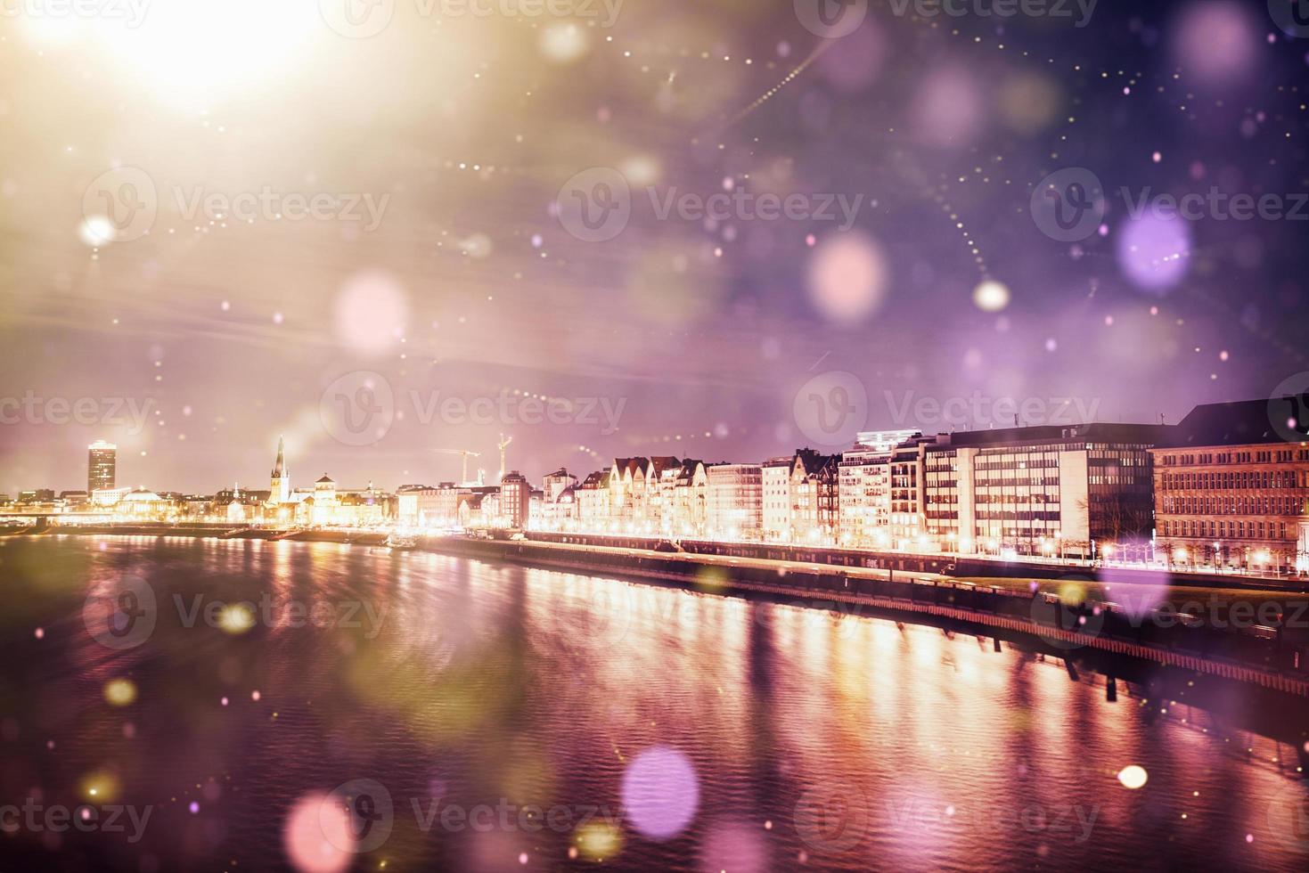 Panorama of the night city of Dusseldorf in winter during a snowstorm. Bokeh light effect, soft filter photo