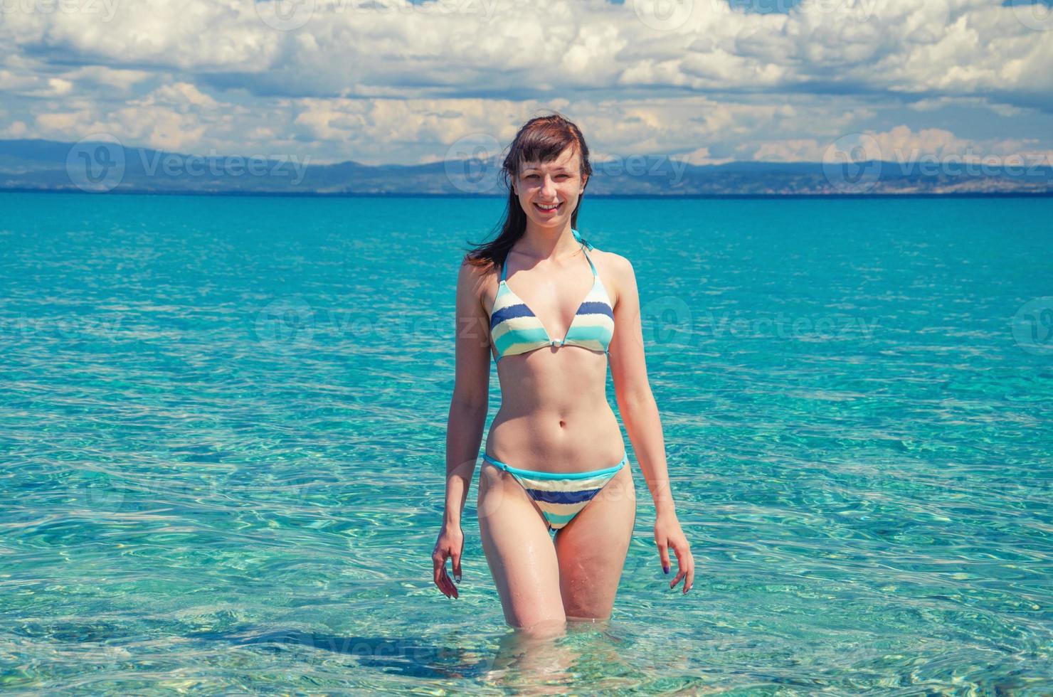 hermosa joven en bikini estancia en aguas turquesas del golfo toroneos kolpos foto