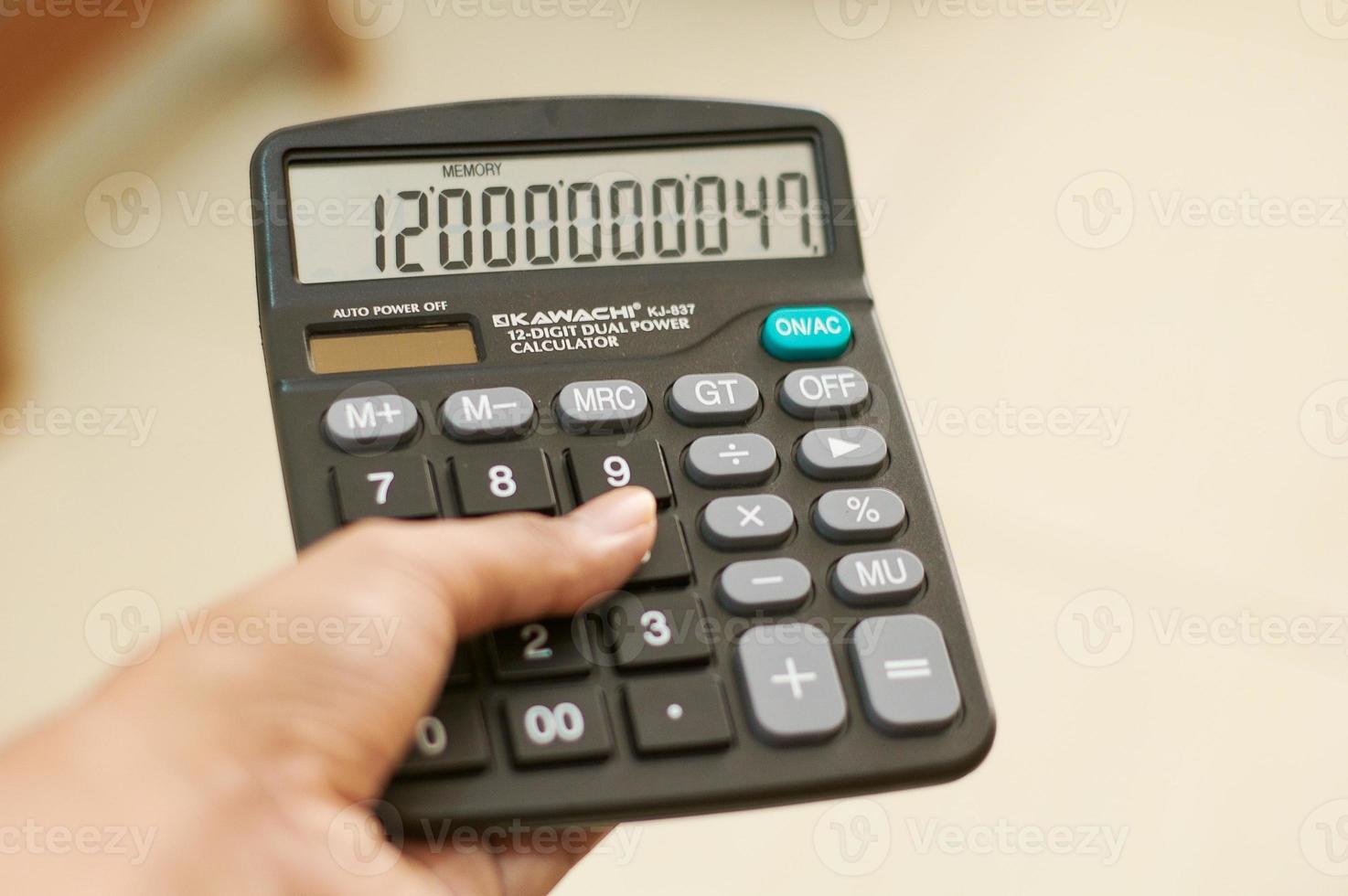 Calculator on Hand with bokeh background photo