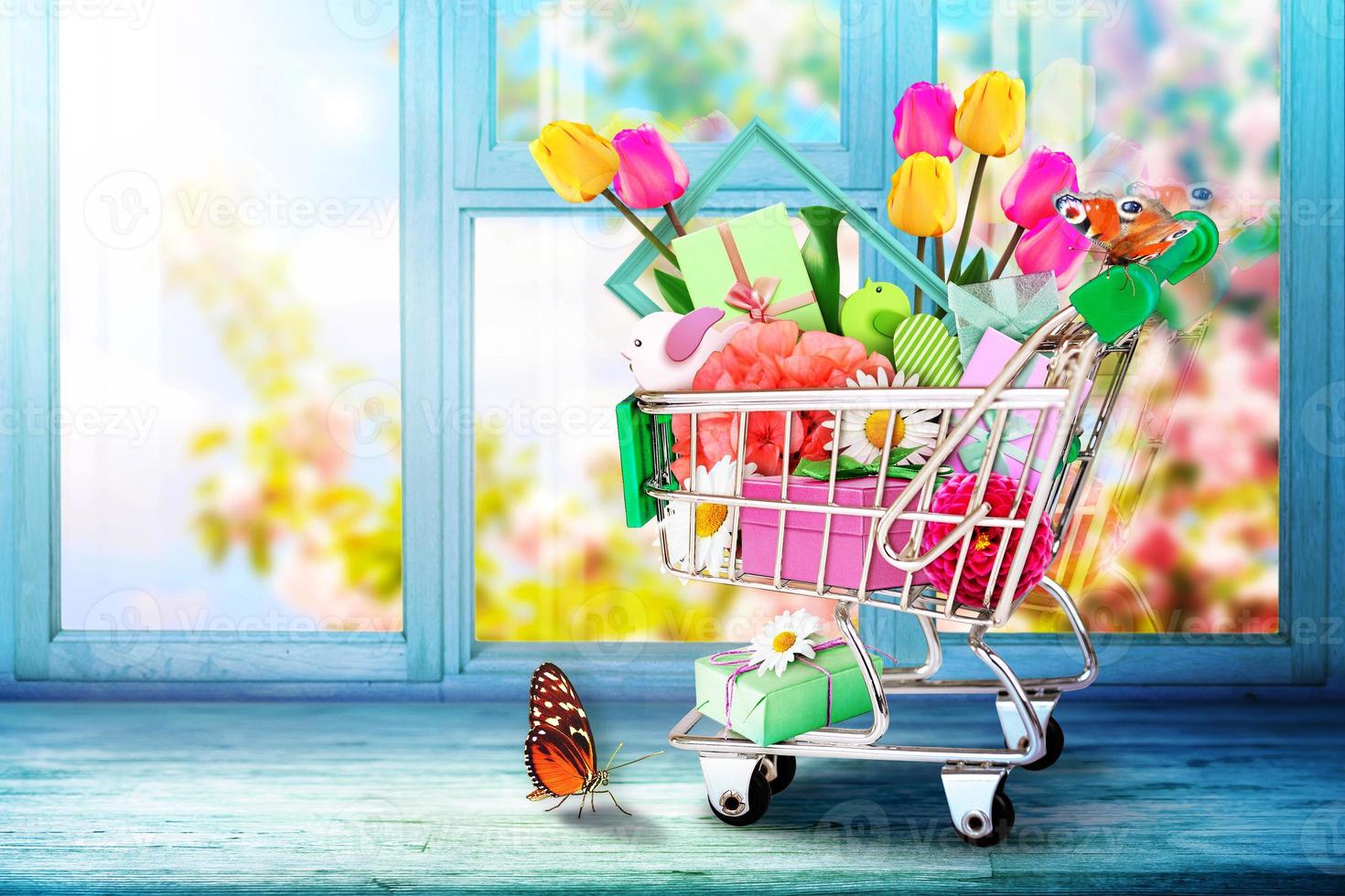 mini carrito de compras con coloridas flores y mariposas. foto