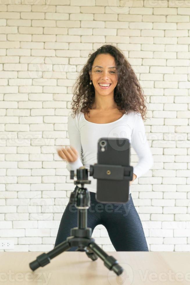 Latin woman created her dancing video by smartphone camera. To share video to social media application. photo