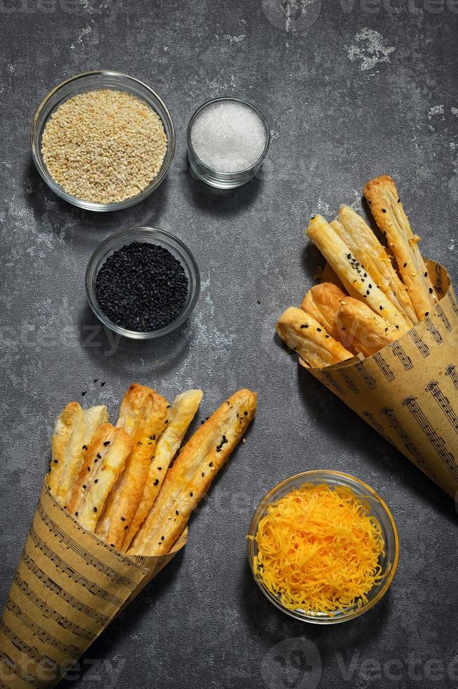 pajitas de queso y semillas de sésamo en un cono de papel foto