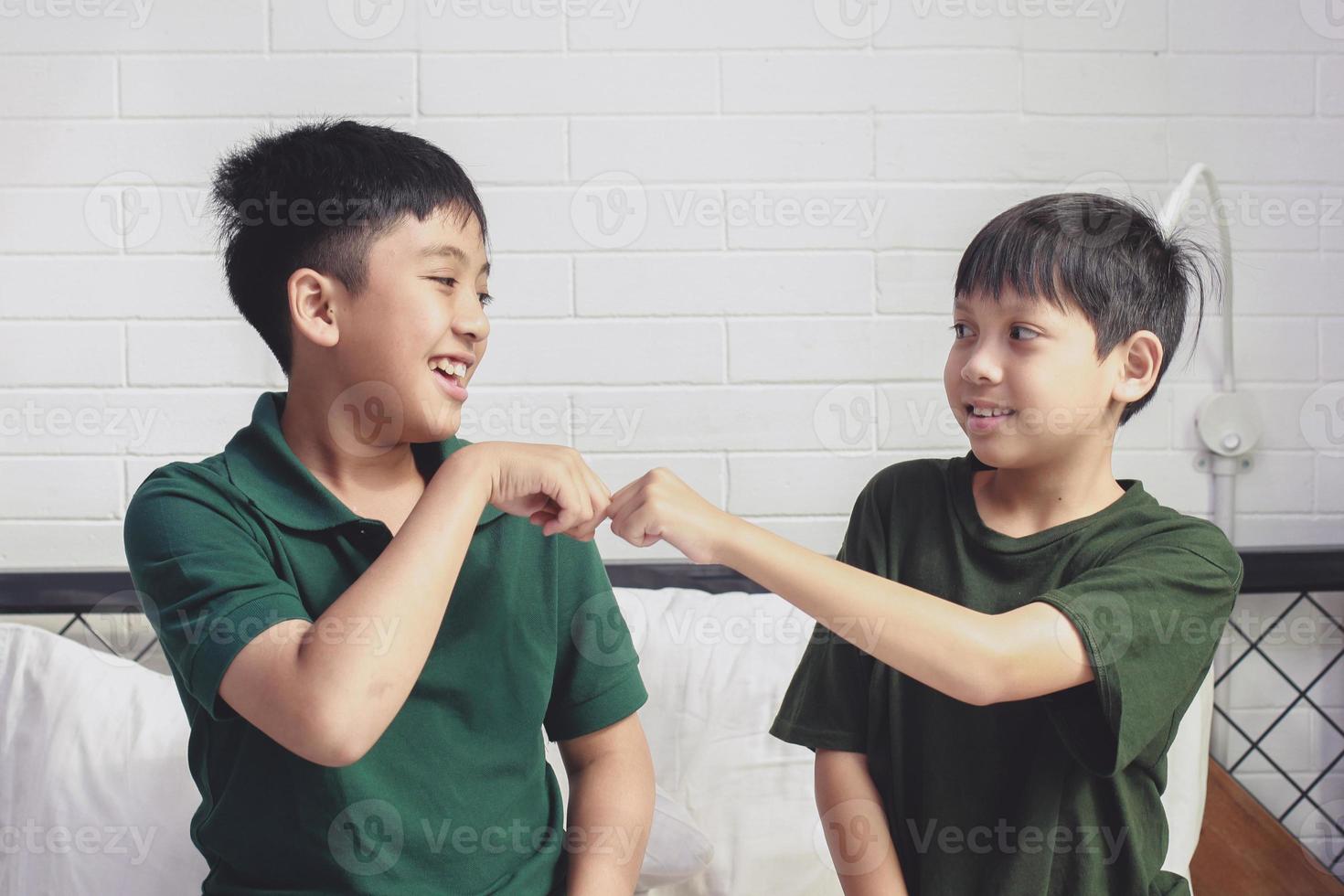 dos hermanos felices dando puñetazos en el dormitorio foto