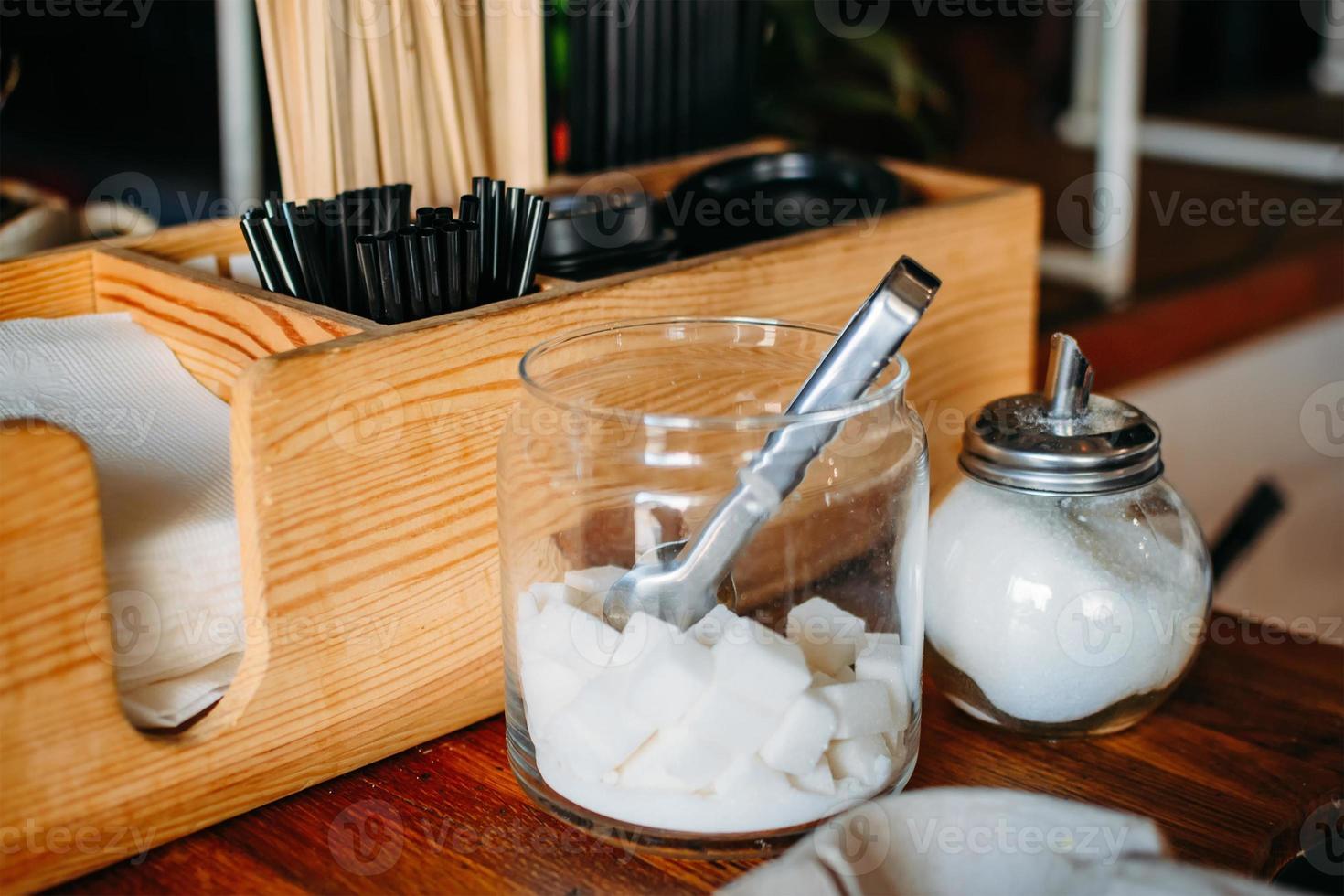 Sugar bowl with sugar cubes in interior of cafe photo