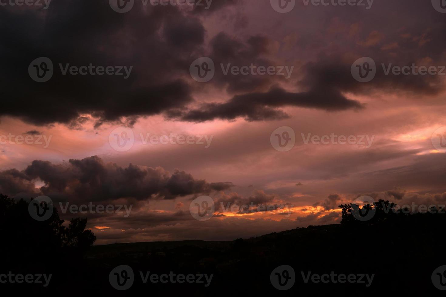 puesta de sol púrpura con nubes grises en primer plano. foto