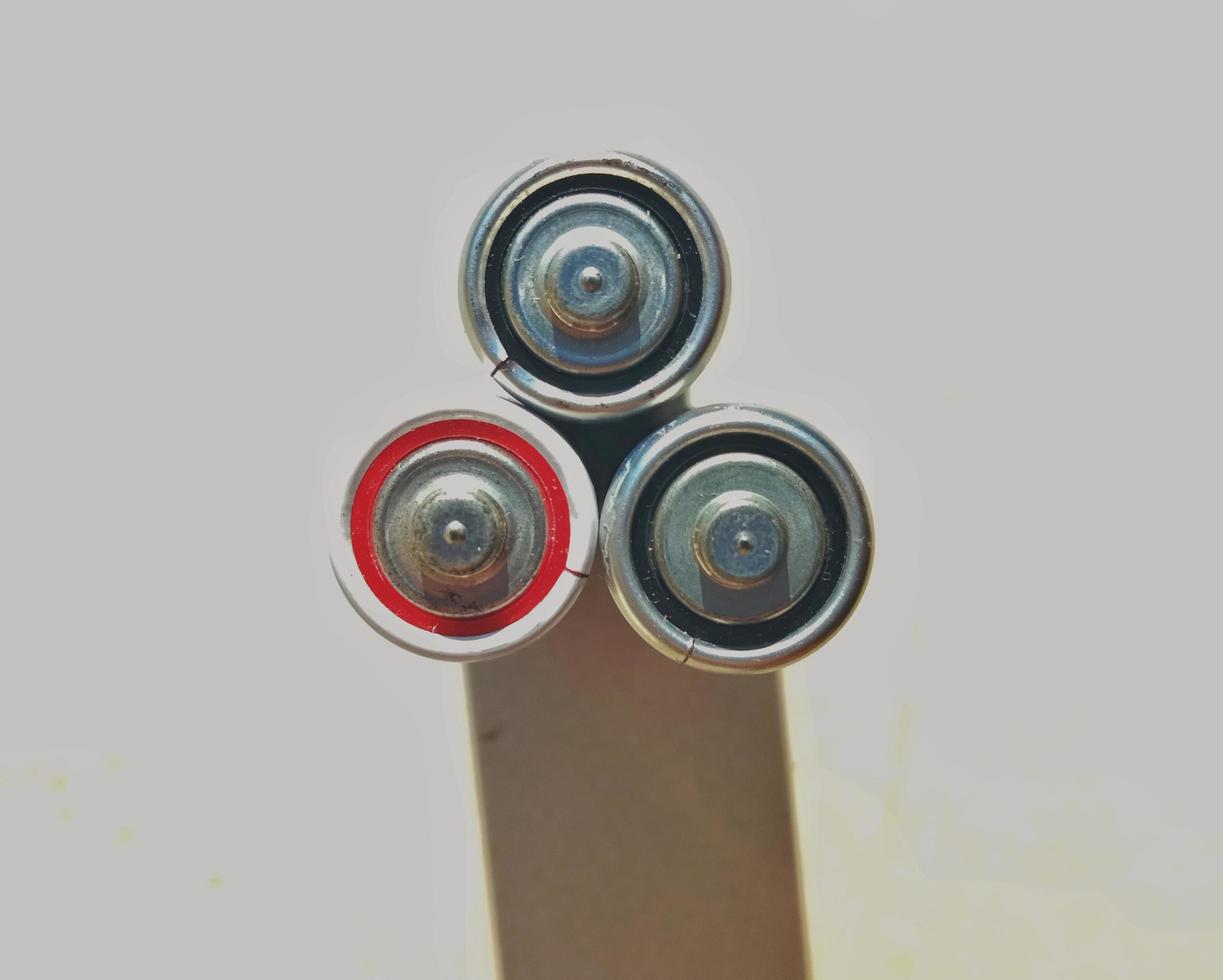 Three batteries are photographed from above and the one seen above. photo