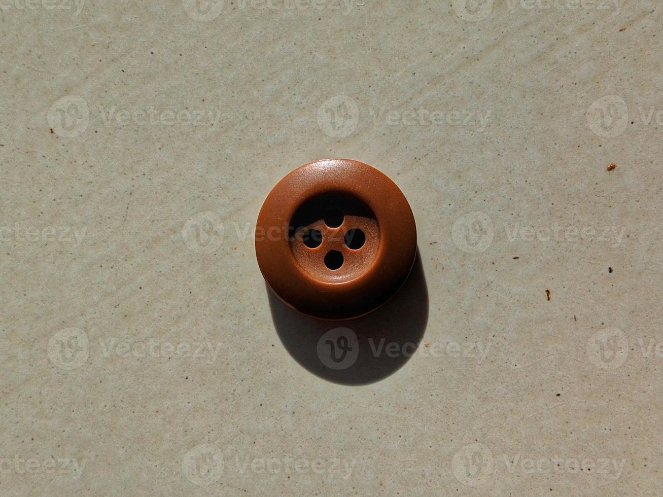 Button up shirt with three brown thread holes. photo