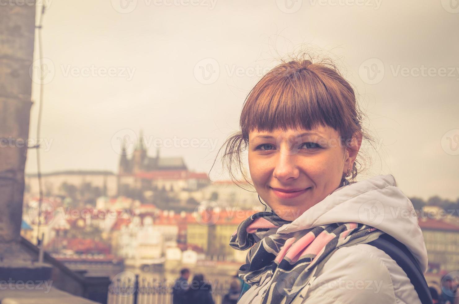 retrato de primer plano de una joven viajera mirando la cámara y sonriendo, castillo de praga foto