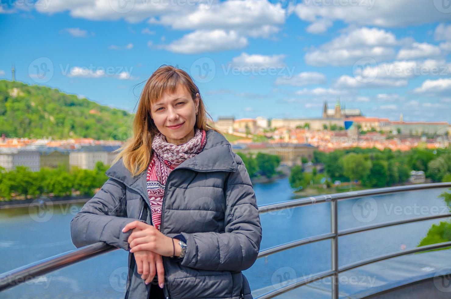 Close-up portrait of young girl tourist looking at camera, posing and smile, Vltava river photo