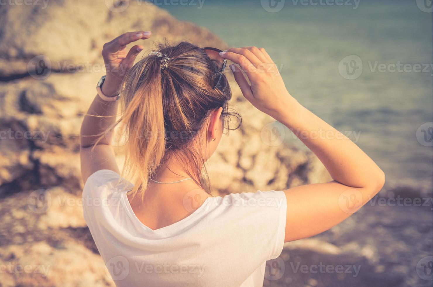 Young woman traveler with white shirt and ponytail stay at beach in Aphrodite bay photo