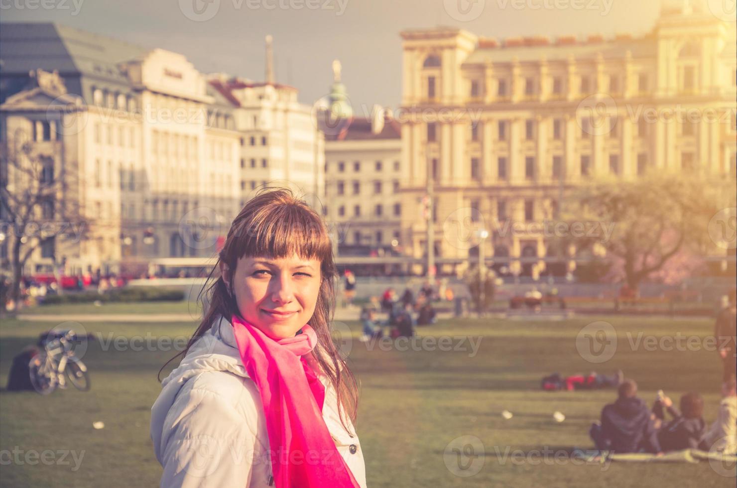 Young girl traveler with white jacket looking away and smile in Sigmund Freud Park of Vienna city historical centre photo