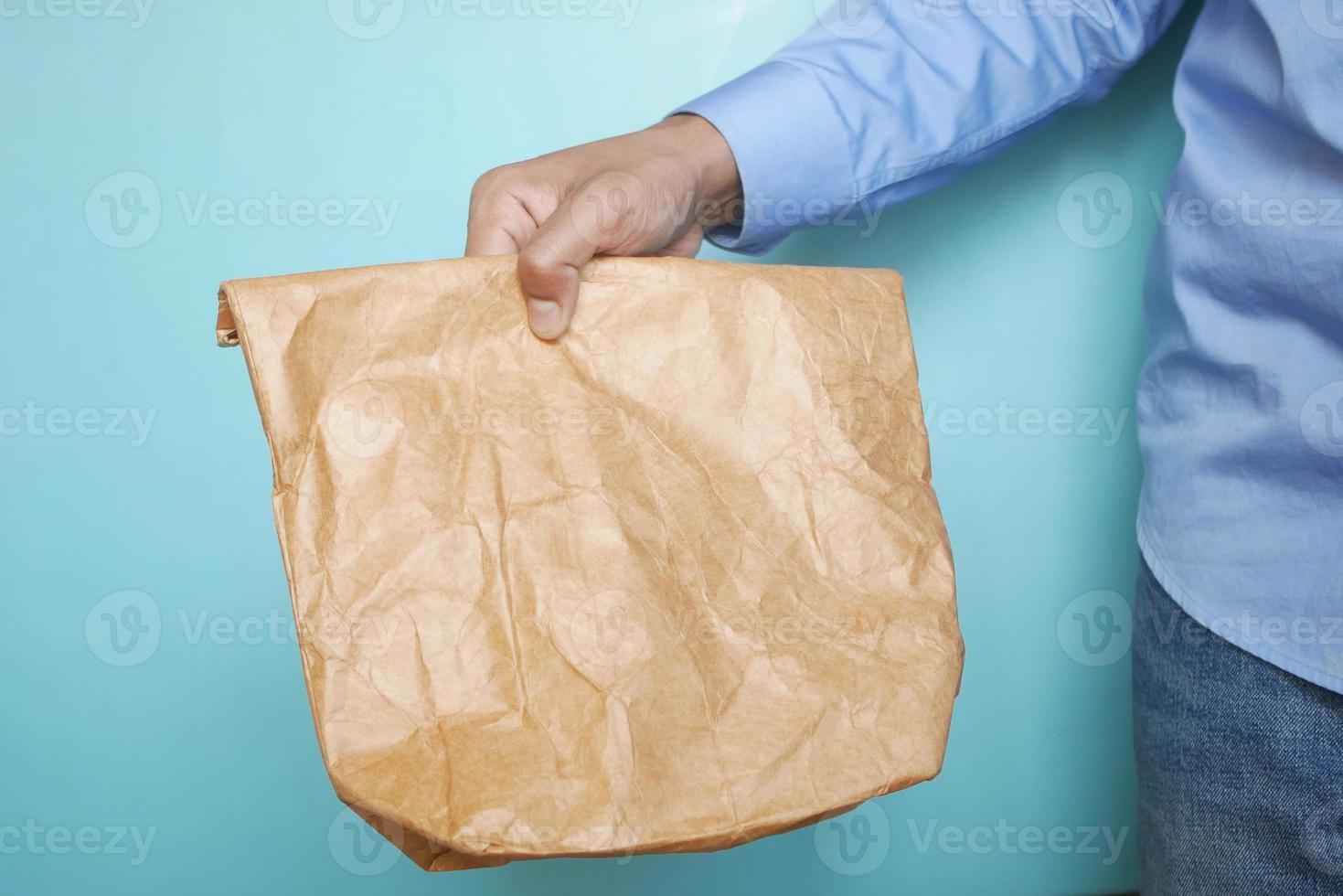 hand holding a paper lunch packet close up photo