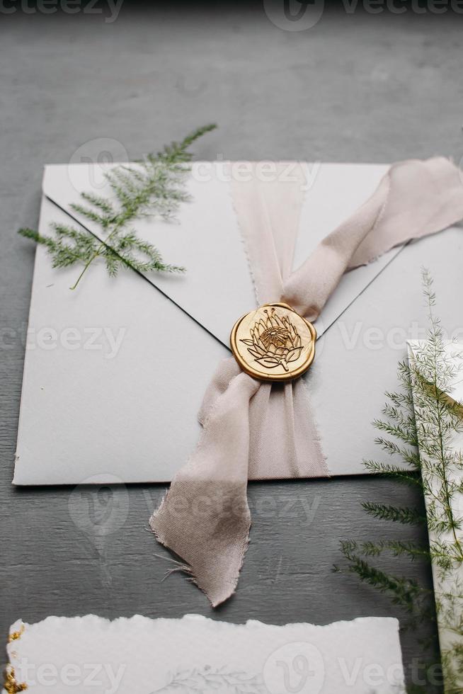 Wedding details flat lay. Wedding invitation and scroll paper. Bottle with fragrance. Ring box. Simple bouquet. photo