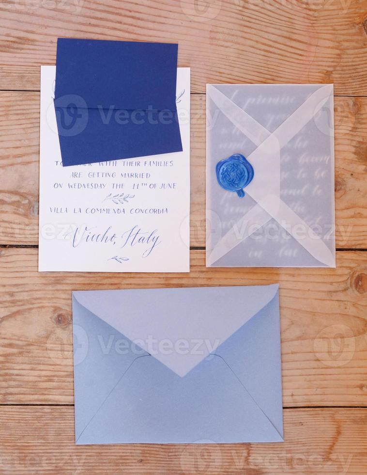 Wedding details flat lay on wooden background. Wedding invitation. Wedding bouquet. Mock up. Envelope. Copy space. photo