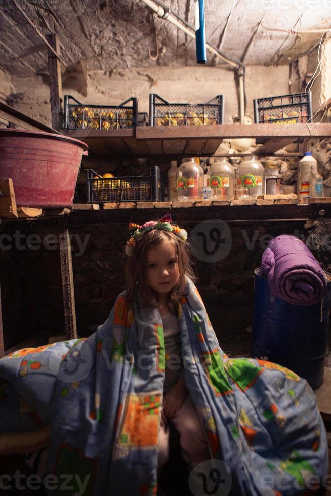 Ukrainian kid takes shelter in her basement. Stop war photo