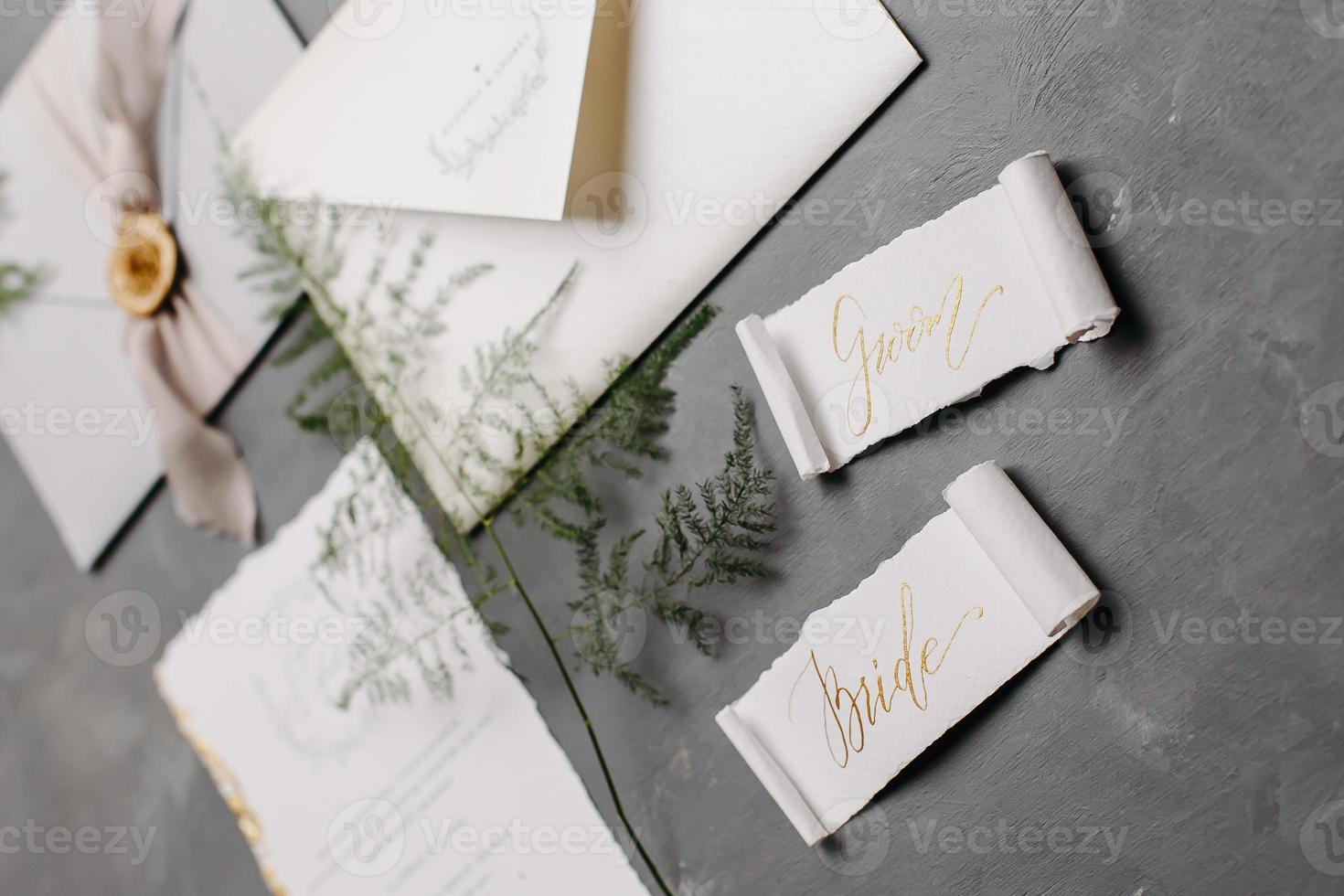 Wedding details flat lay. Wedding invitation and scroll paper. Bottle with fragrance. Ring box. Simple bouquet. photo