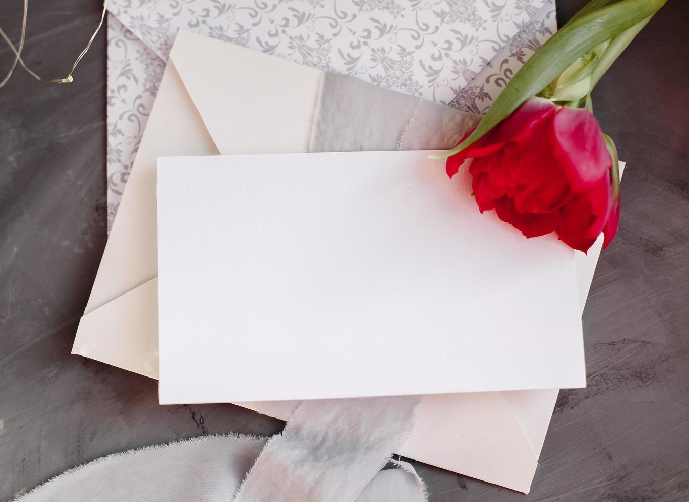 Blank paper copy space. Frame with flowers. Silk ribbon. Gray background. Simple bouquet. Greeting card. photo