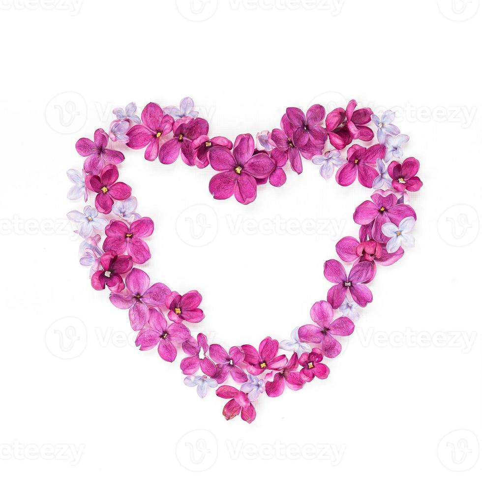 corazón hecho de pétalos de lila. tarjeta de felicitación con corazón y flor lila de cinco puntas. copie el espacio foto