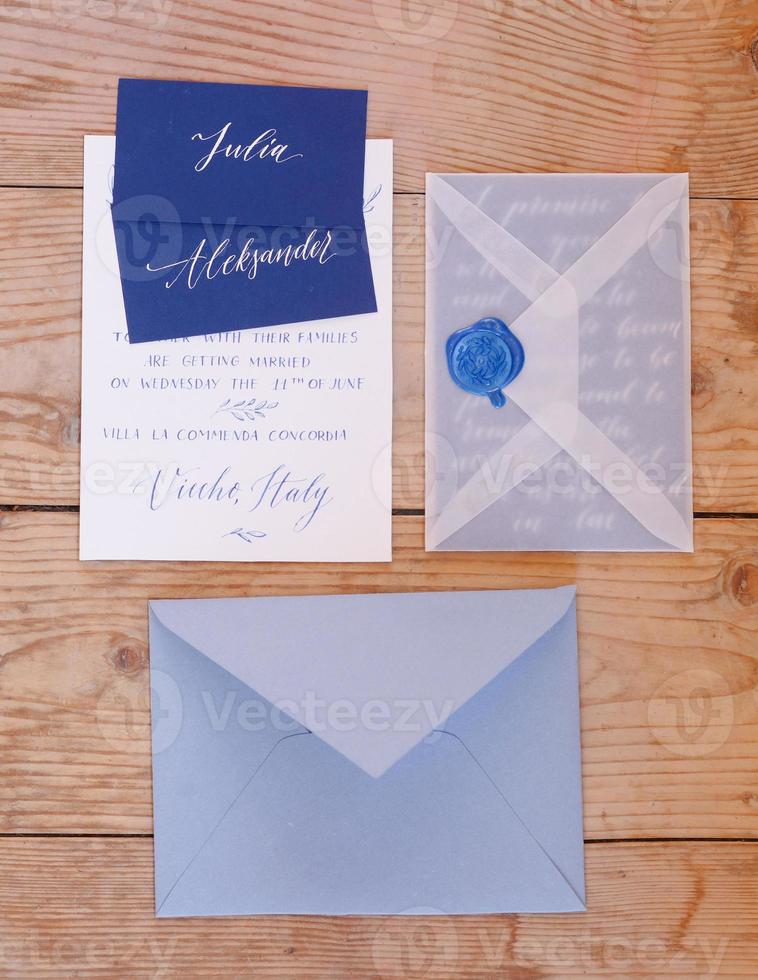 Wedding details flat lay on wooden background. Wedding invitation. Wedding bouquet. Mock up. Envelope. Copy space. photo
