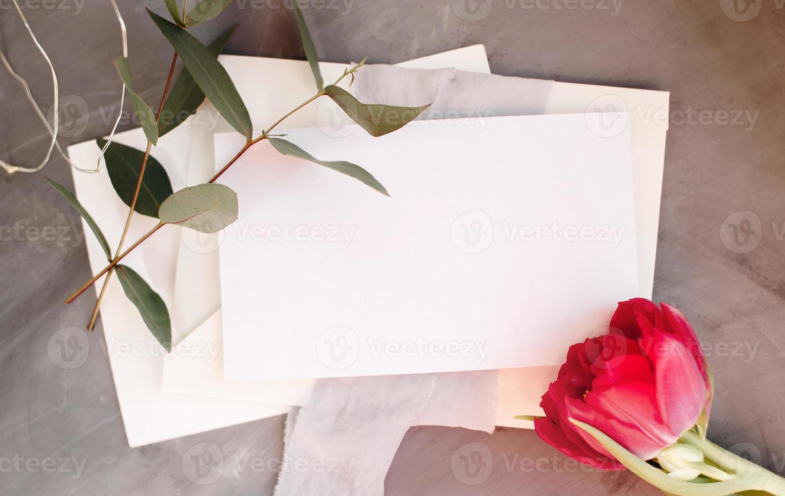 Blank paper copy space. Frame with flowers. Silk ribbon. Gray background. Simple bouquet. Greeting card. photo