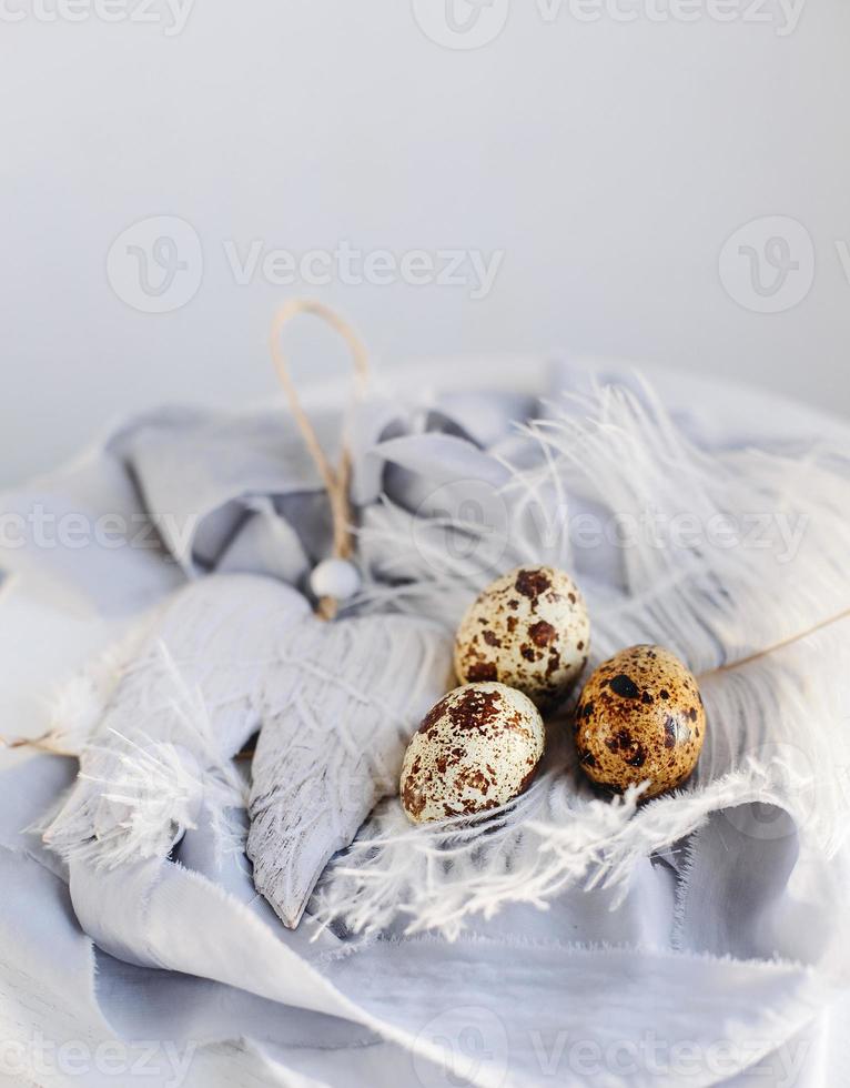 huevos de pascua con pluma blanca sobre fondo blanco y gris. felices vacaciones de pascua, vista frontal superior. foto