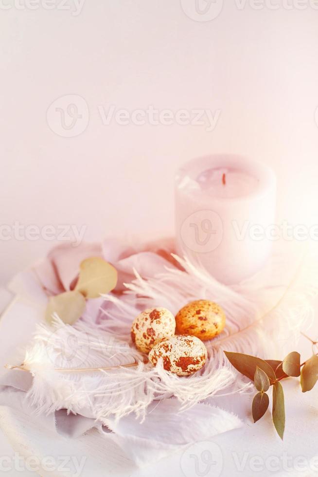 huevos de pascua con pluma blanca sobre fondo blanco y gris. felices vacaciones de pascua, vista frontal superior. foto