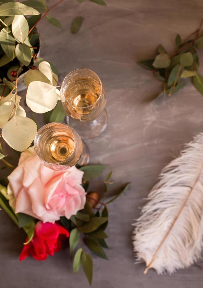Composition with glasses of vine and flowers on grey concrete background. photo