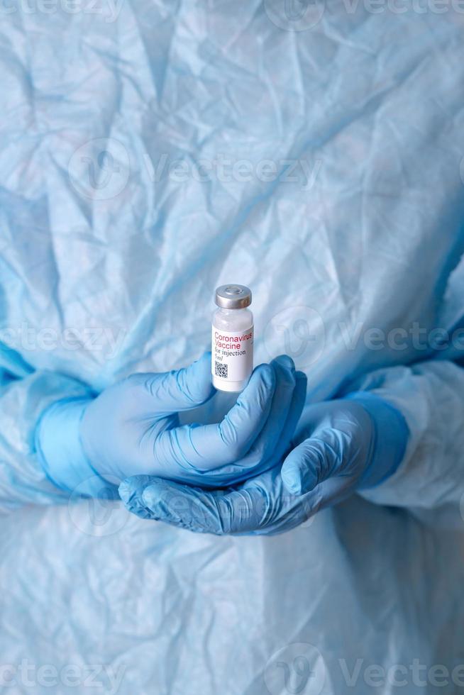 Coronavirus vaccine. Doctor with a vaccine. Nurse holding a coronavirus vaccine. Hands holding a coronavirus vaccine ampoule, against Covid-19 photo