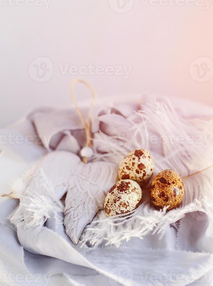 huevos de pascua con pluma blanca sobre fondo blanco y gris. felices vacaciones de pascua, vista frontal superior. foto