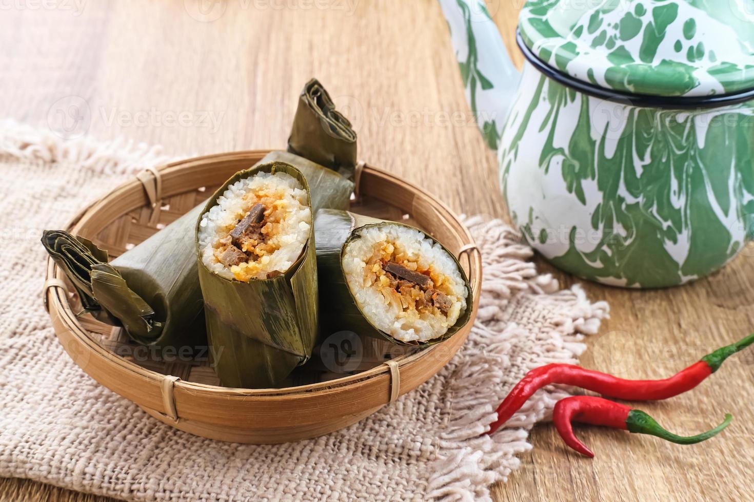Arem-arem, a traditional Indonesian food made from rice filled with vegetables, chicken, meat or tempeh wrapped in banana leaves. Arem-arem is popular as a breakfast substitute. Selected focus. photo