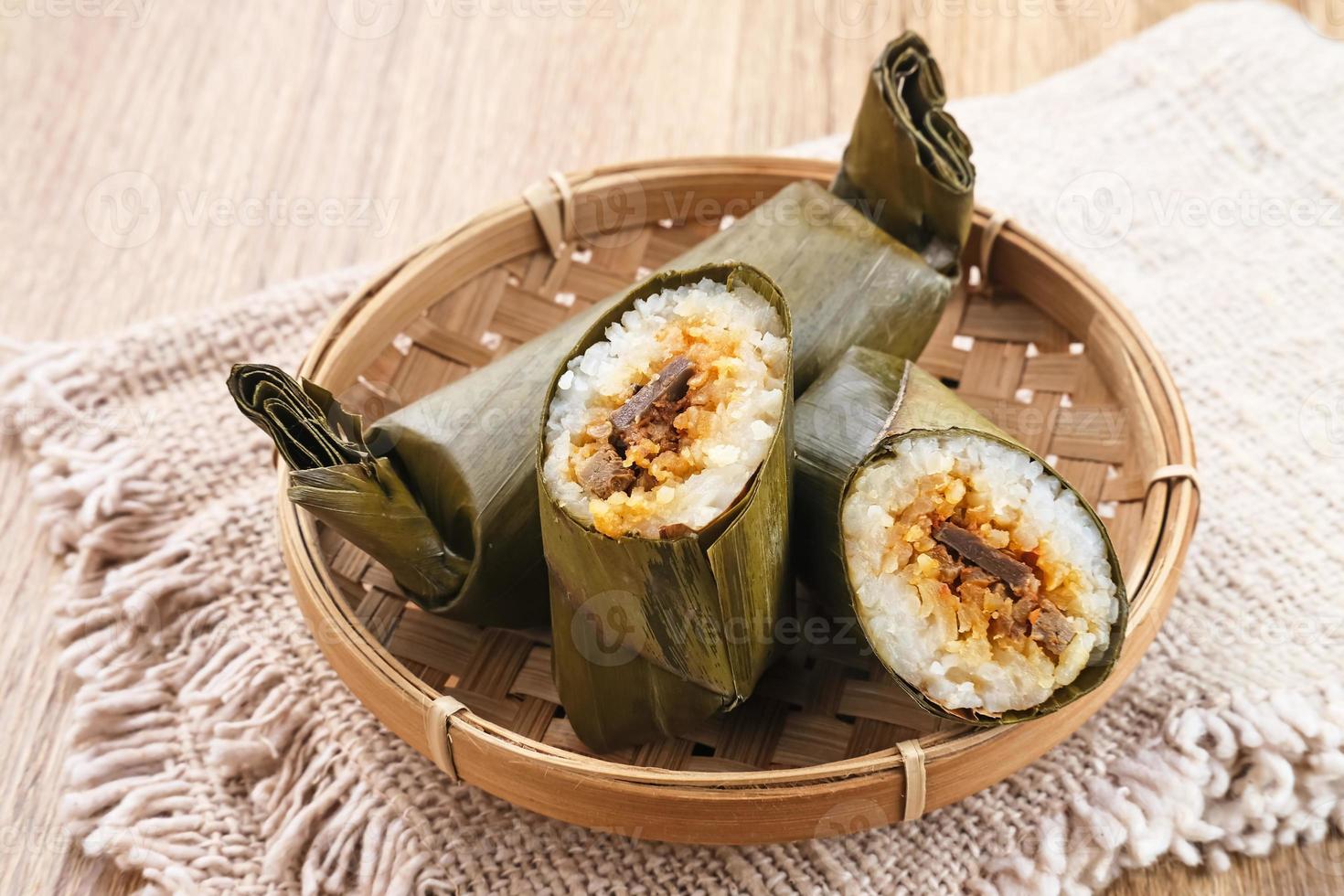 Arem-arem, a traditional Indonesian food made from rice filled with vegetables, chicken, meat or tempeh wrapped in banana leaves. Arem-arem is popular as a breakfast substitute. Selected focus. photo