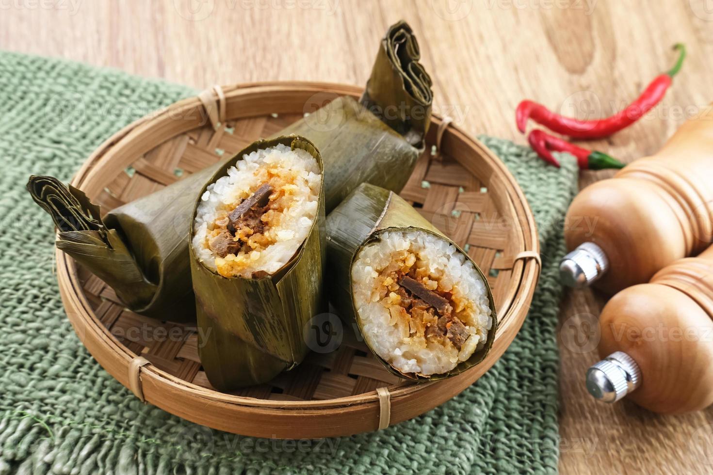 Arem-arem, a traditional Indonesian food made from rice filled with vegetables, chicken, meat or tempeh wrapped in banana leaves. Arem-arem is popular as a breakfast substitute. Selected focus. photo